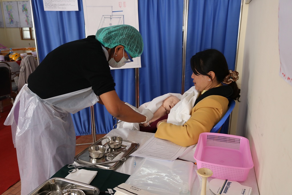 A State Health Training Team Member practices newborn care with a simulation model at Lashio L&PIC, Northern Shan State.
